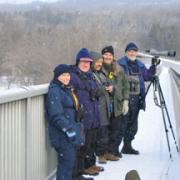 Picture of Bill and Heather with friends bird watching from a snowy bridge